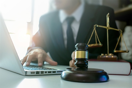 lawyer with laptop, gavel, and scales on desk